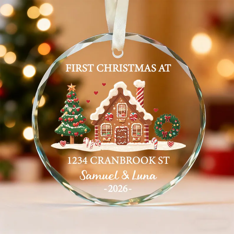 A round glass ornament with gingerbread house and christmas tree